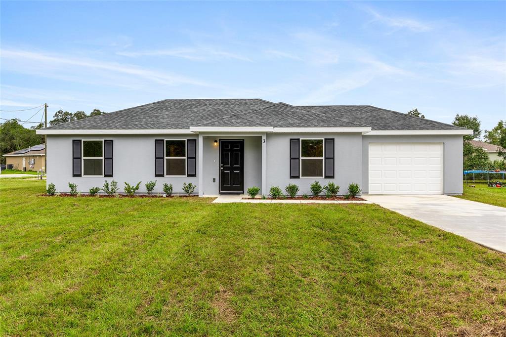 A single-story gray house features a black front door, dark shutters, and an attached garage — 229 LOCUST LANE, OCALA, FL
