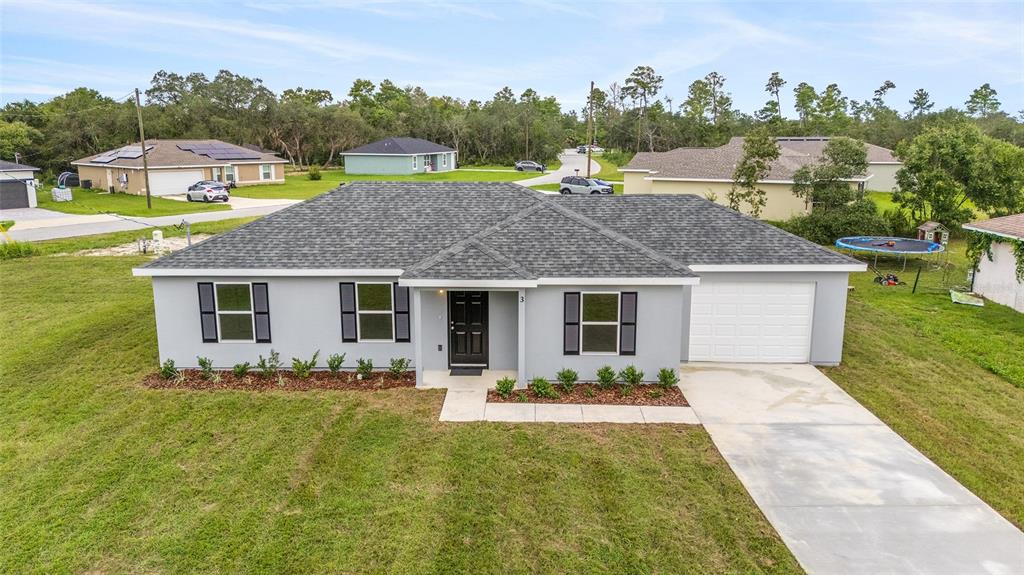 A single-story gray house with a dark shingled roof, black shutters, and a concrete driveway — 229 LOCUST LANE, OCALA, FL