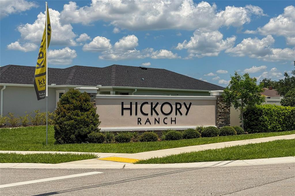 A stone and stucco monument sign for Hickory Ranch stands in front of a house — 211 ASH WAY, AUBURNDALE, FL