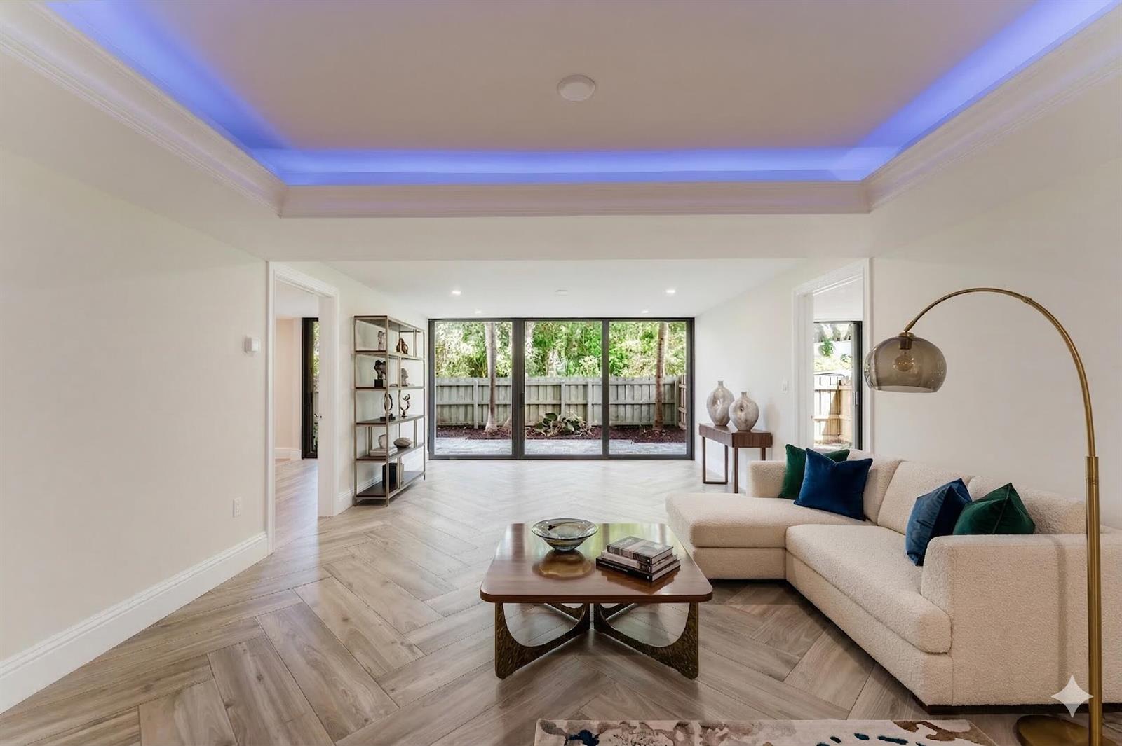 A living room with herringbone wood floors, a tray ceiling with blue lighting, and floor-to-ceiling windows — 501 SW 11th Place # 114, Boca Raton FL 33432, BOCA RATON, FL