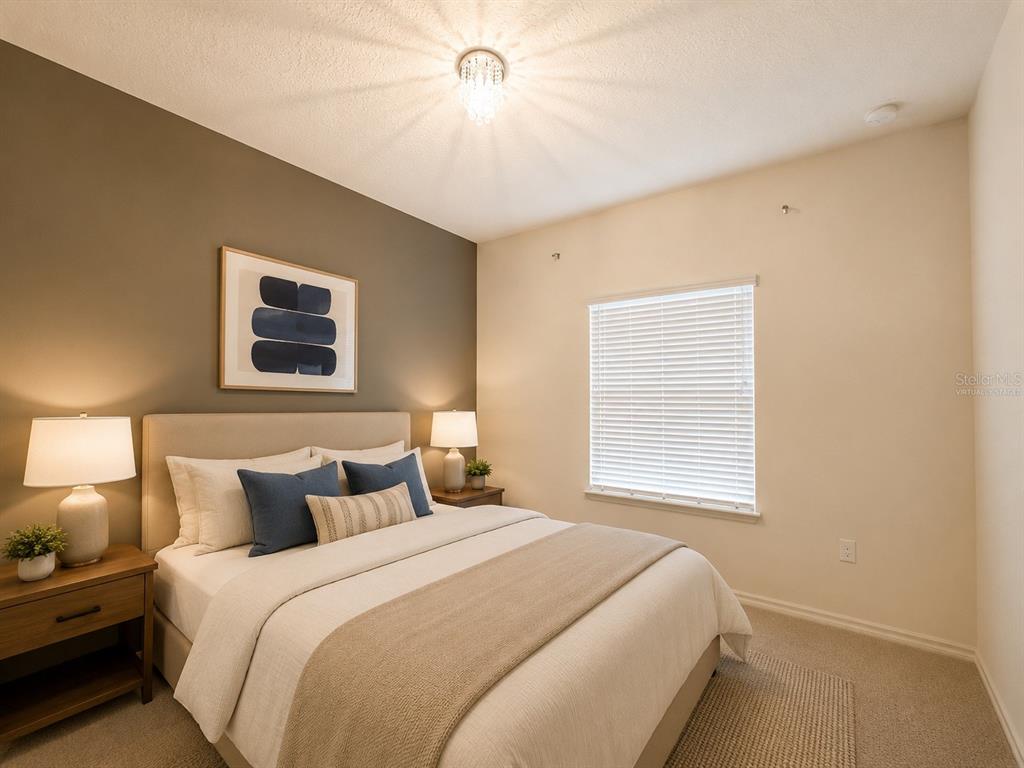 A bedroom features a queen bed, two nightstands with lamps, and a dark accent wall — 3208 OYSTER LANE, KISSIMMEE, FL