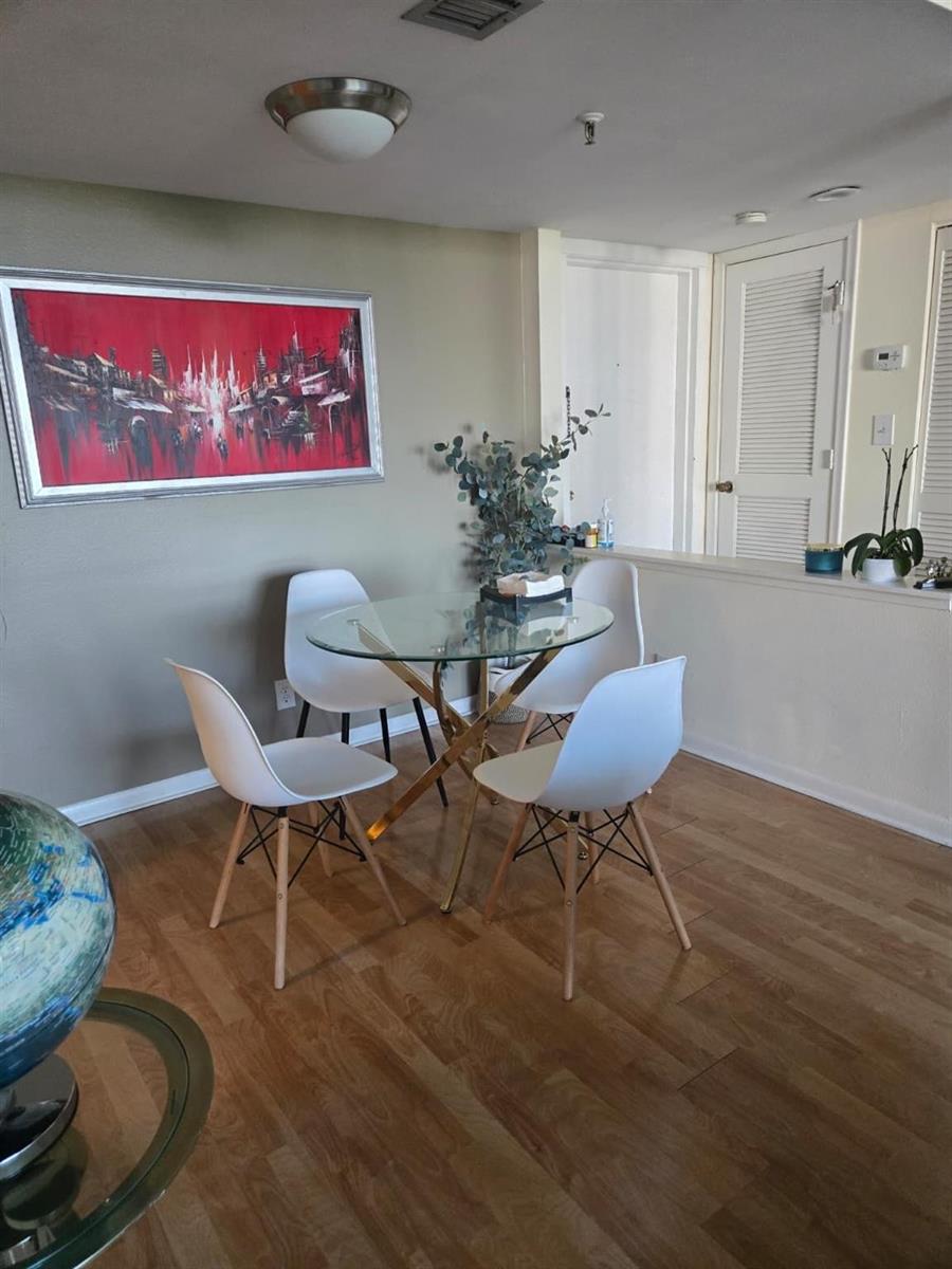 A dining area features a glass-topped table, four white chairs, and a large red painting — 6797 Willow Wood Drive # 6073, Boca Raton FL 33434, BOCA RATON, FL