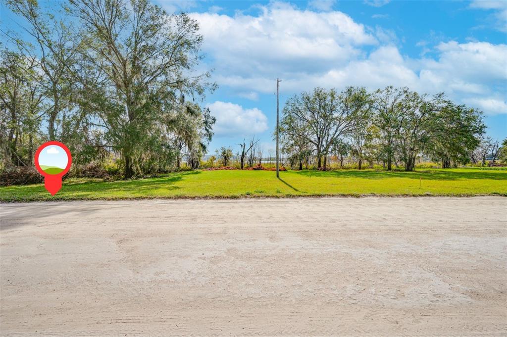 A dirt road runs in front of a grassy, tree-lined vacant lot — 0000 MCKENDREE ROAD, WESLEY CHAPEL, FL