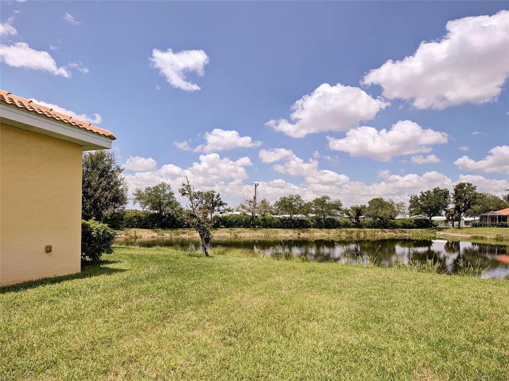 A dark brown front door with a side window sits at the end of a walkway — 8938 PEREGRINE WAY, NORTH PORT, FL