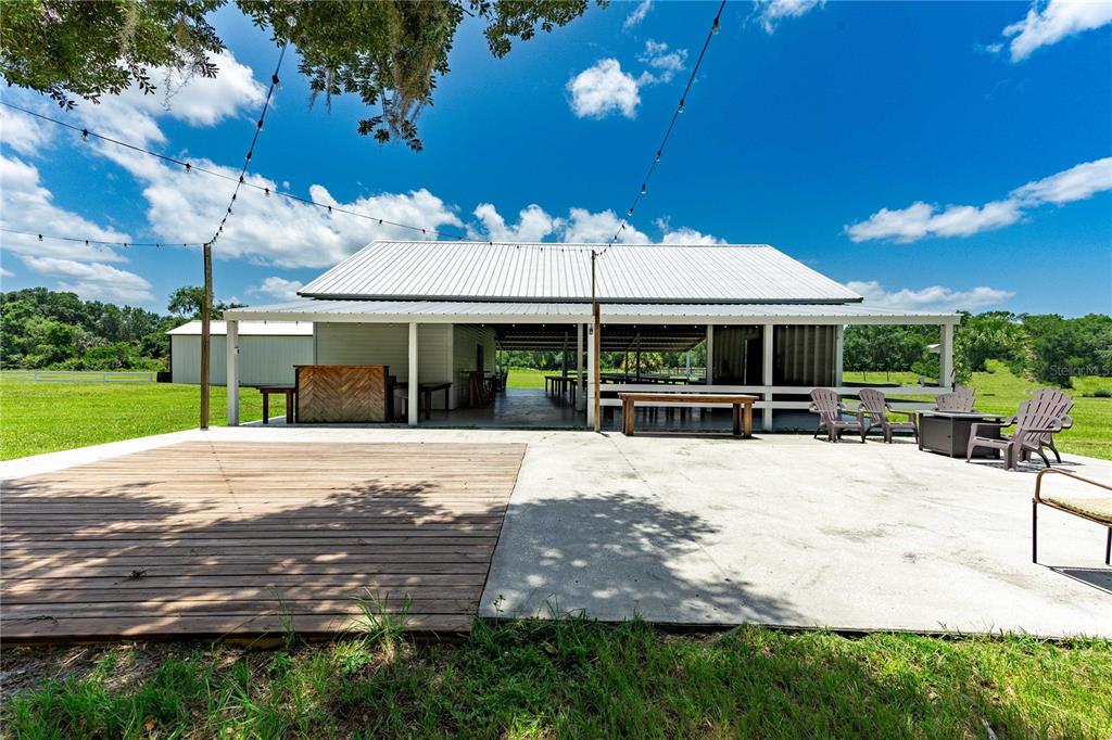 An outdoor patio features a wooden dance floor, concrete area, and a covered pavilion structure — 4773 SW 47TH BOULEVARD, BUSHNELL, FL