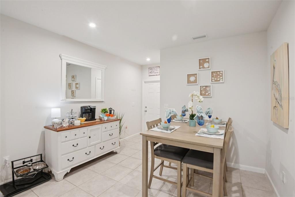 A dining area features a light wood table with four chairs and a white sideboard — 4167 HARBOUR PALM DRIVE, HOLIDAY, FL