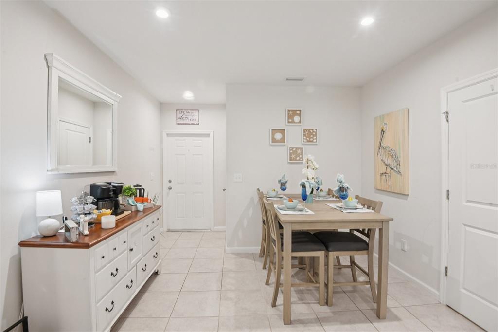 A dining room features a wooden table with four chairs, a white sideboard, and tile flooring — 4167 HARBOUR PALM DRIVE, HOLIDAY, FL