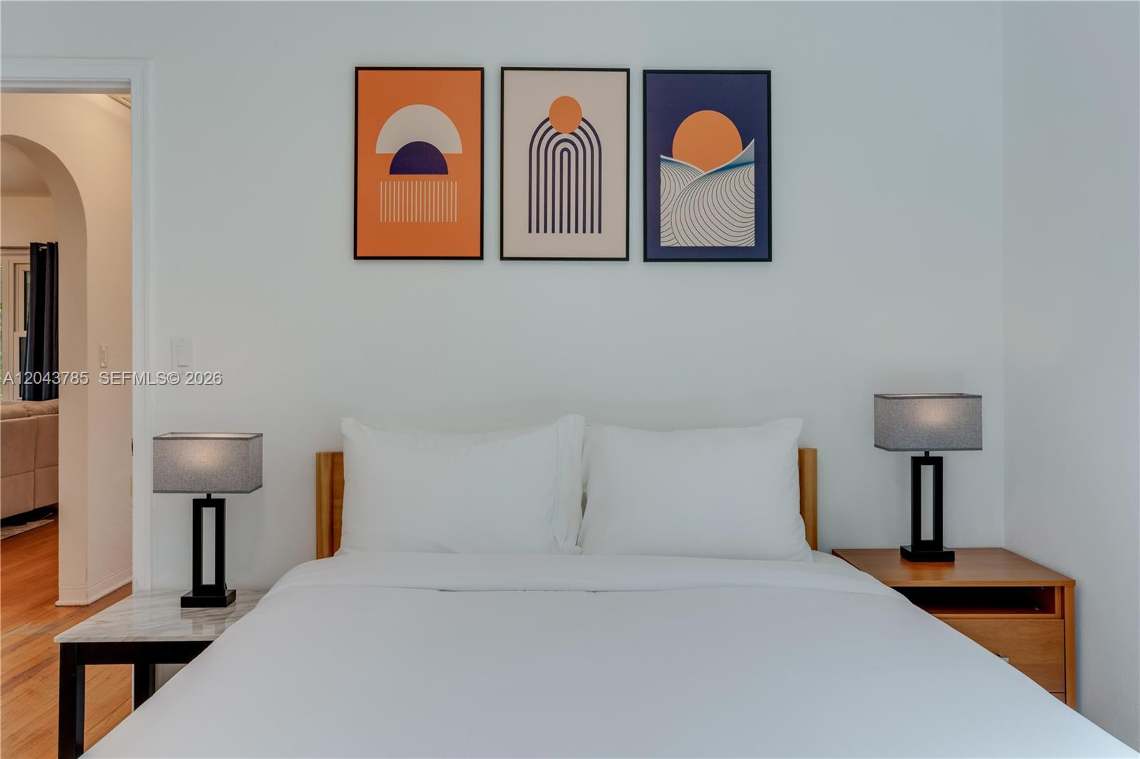 A bedroom features a bed with white bedding, two lamps, and three abstract wall prints — 820 SW 26th Rd, Miami FL 33129, MIAMI, FL
