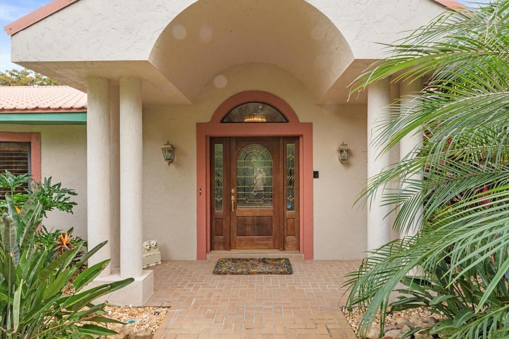 A front entryway features a wooden door with glass inserts, columns, and a brick walkway — 4345 CORLEY ISLAND ROAD, LEESBURG, FL