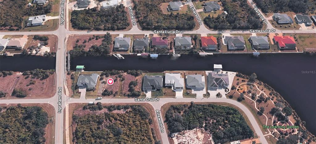 An aerial view showing a vacant residential lot marked with a heart icon near a canal — 8618 SANTA CRUZ DRIVE, PORT CHARLOTTE, FL