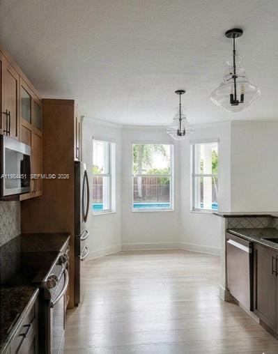 A kitchen with light wood floors, dark cabinets, stainless steel appliances, and two pendant lights — 16364 SW 63rd Ter, Miami FL 33193, MIAMI, FL