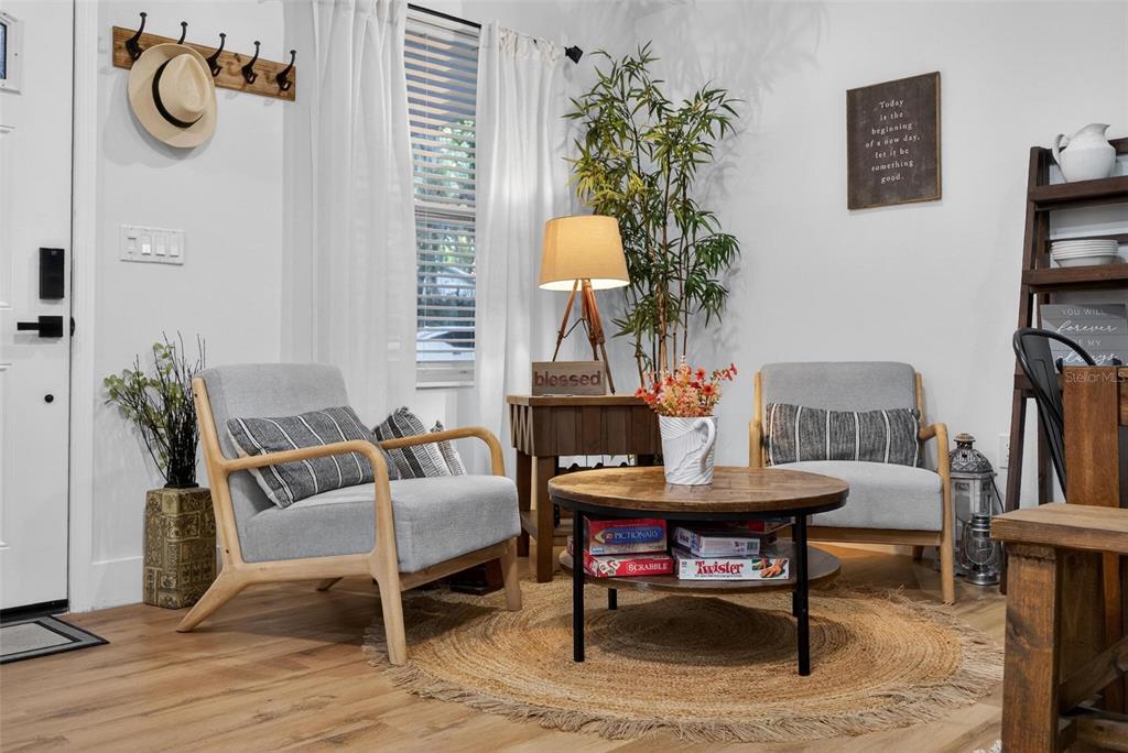 A living area features two grey armchairs, a round coffee table, and a wooden side table — 1503 GRANITE STATE COURT, MOUNT DORA, FL
