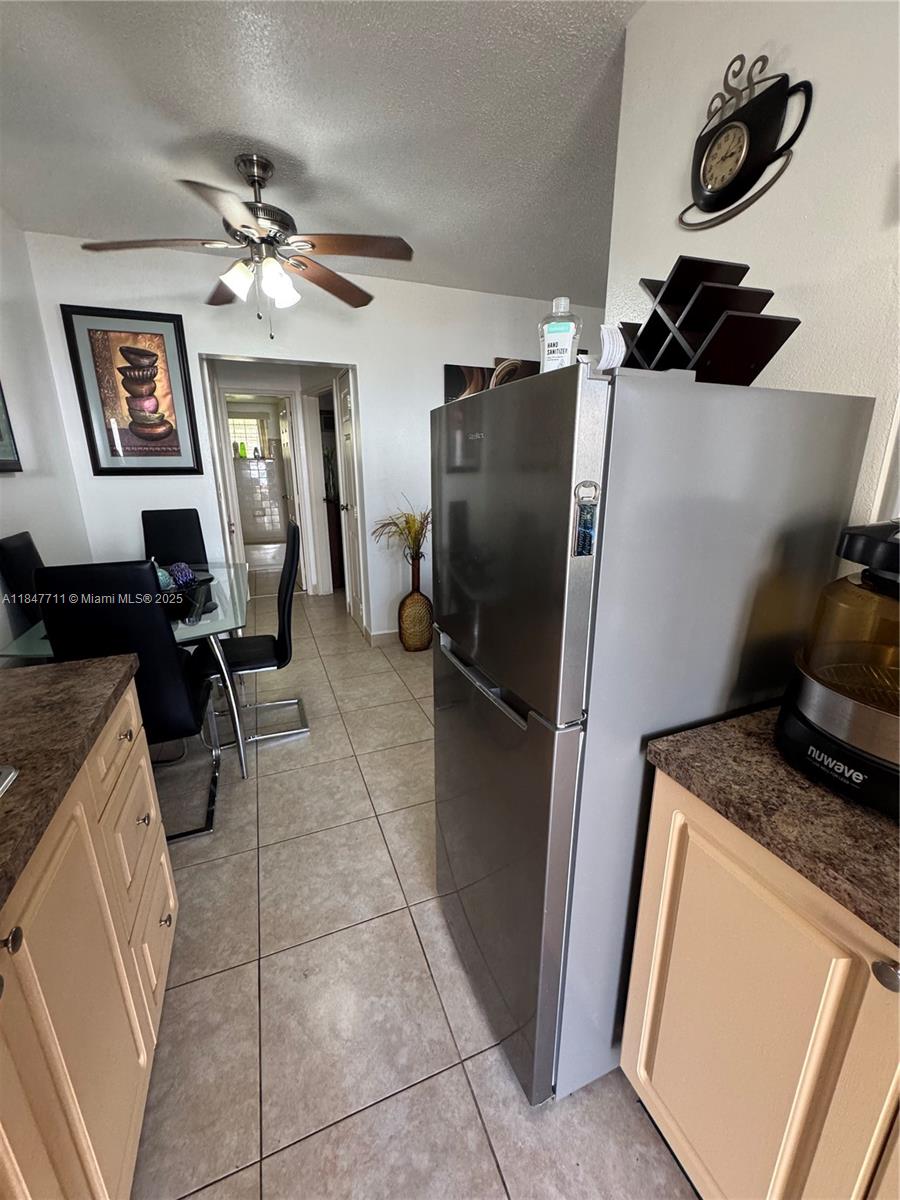 A kitchen with stainless steel appliances, light-colored cabinets, and an adjacent dining area — 71 NW 76th St # 5, Miami FL 33150, MIAMI, FL