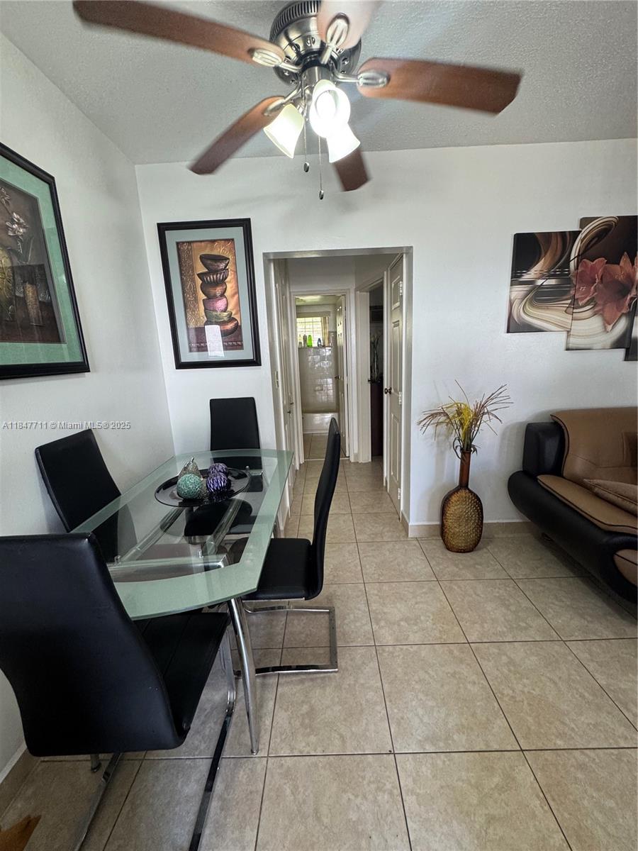 A dining area features a glass table, black chairs, tile flooring, and a ceiling fan — 71 NW 76th St # 5, Miami FL 33150, MIAMI, FL