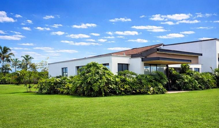 A modern, white single-story house with a flat roof sits on a large green lawn — Finca La Pradera Montenegro Quindio Colombia, FL
