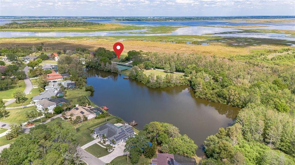 An aerial view shows a residential neighborhood with houses bordering a lake and wetlands — 0 HIDDEN HARBOR LANE, KISSIMMEE, FL