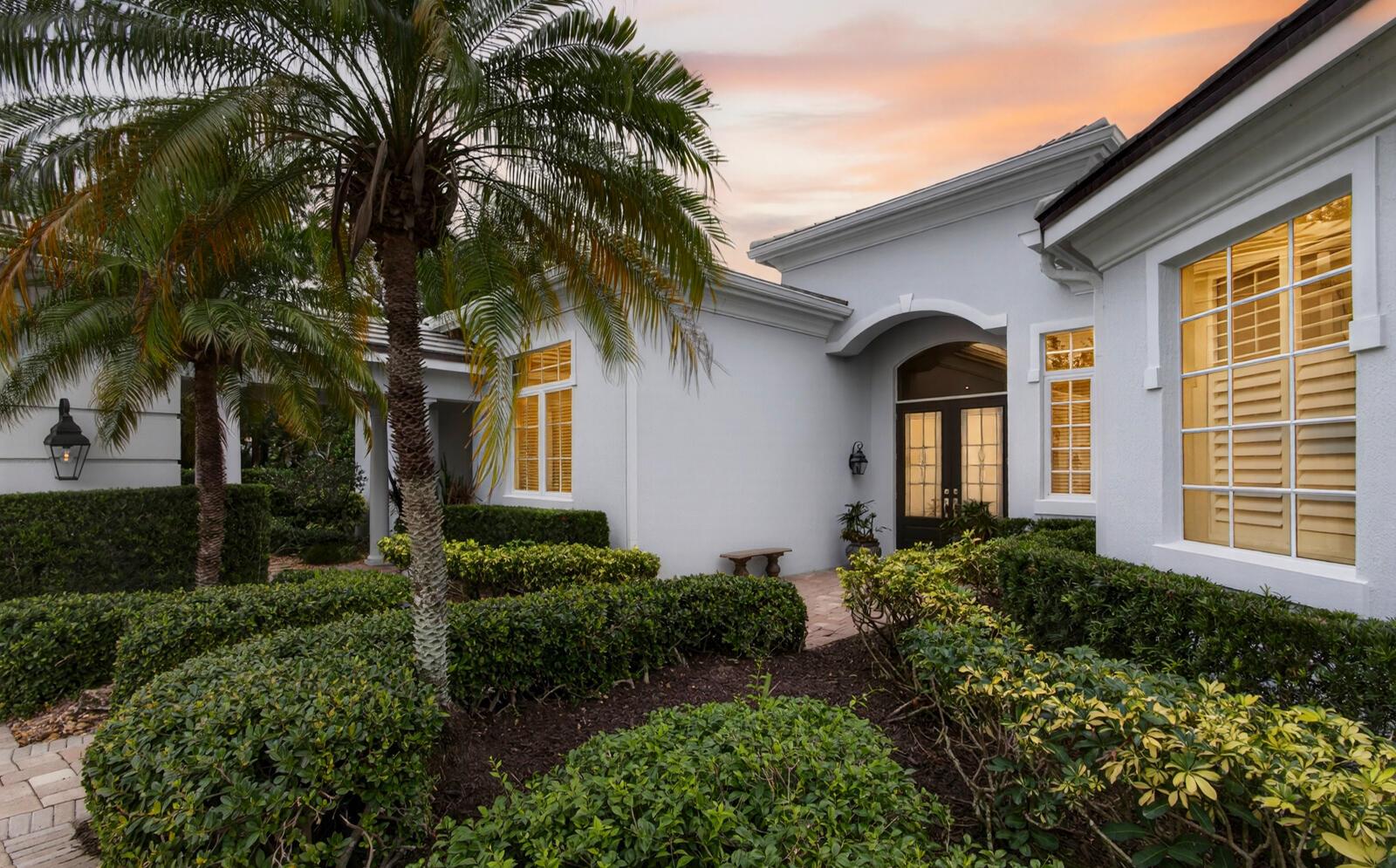 A white house exterior features a palm tree, manicured hedges, and a front entryway — 1301 Cape Pointe Circle, Vero Beach FL 32963, VERO BEACH, FL