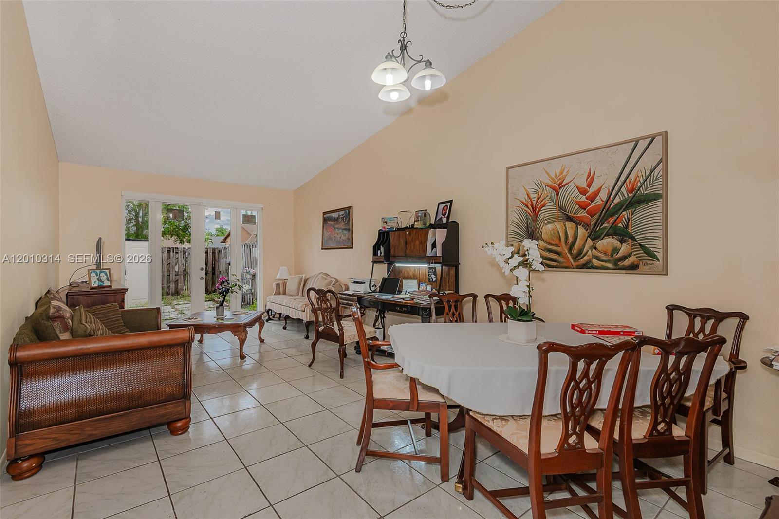 A living and dining area features tile floors, vaulted ceilings, and a sliding glass door — 6745 NW 192nd Ln, Hialeah FL 33015, HIALEAH, FL