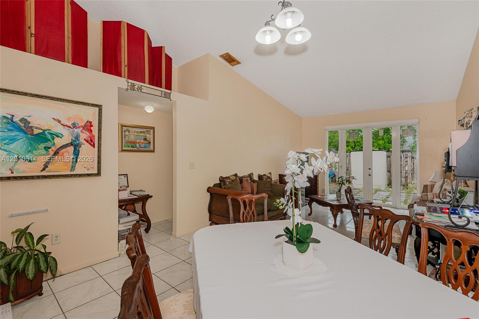 A dining area with tile floors and a vaulted ceiling opens into a living space — 6745 NW 192nd Ln, Hialeah FL 33015, HIALEAH, FL