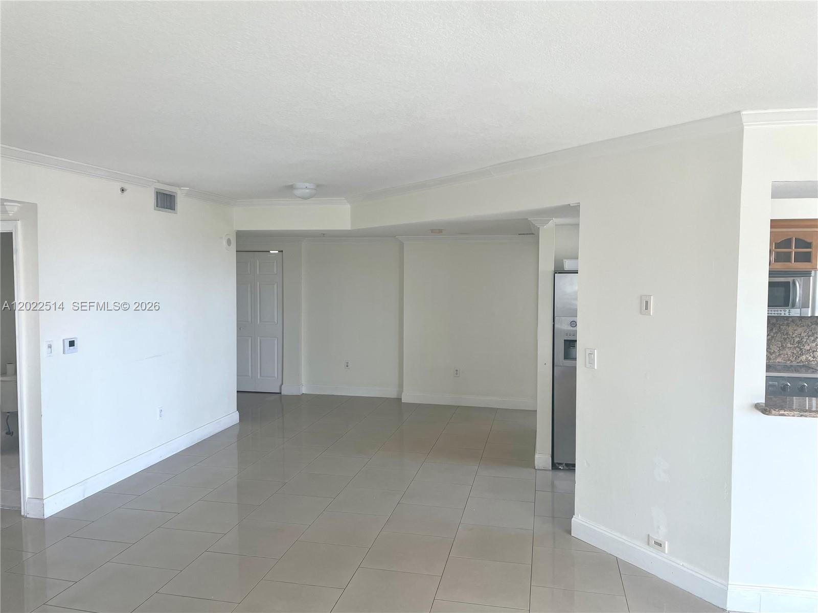An interior view shows a living area with light tile flooring and an adjacent kitchen — 4242 NW 2nd St # 1002, Miami FL 33126, MIAMI, FL
