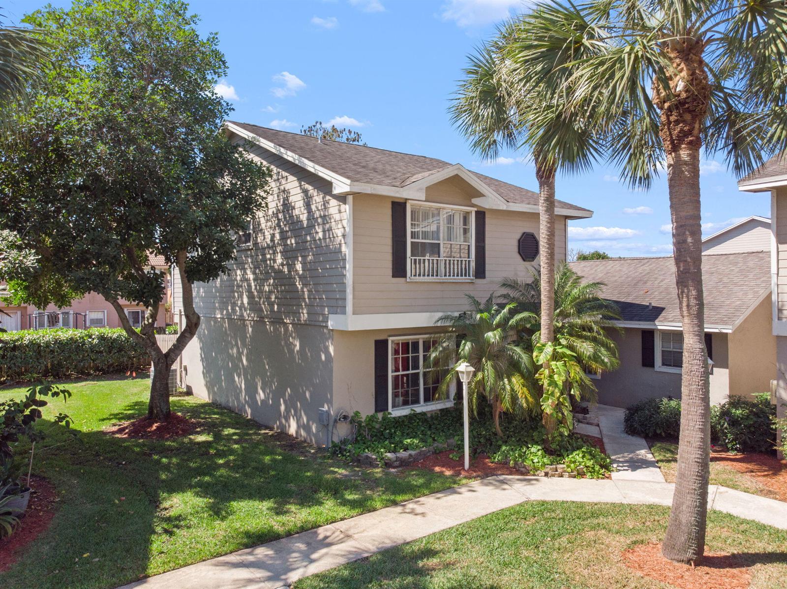 A two-story tan house with a shingled roof, palm trees, and a concrete walkway — 12212 NW 36th Place, Sunrise FL 33323, SUNRISE, FL