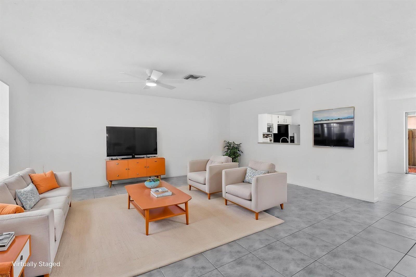 A living room with light-colored tile floors, a beige area rug, and neutral-toned furniture — 12212 NW 36th Place, Sunrise FL 33323, SUNRISE, FL