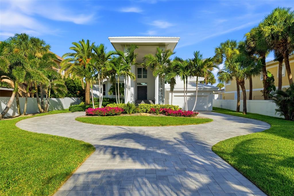 A white two-story house with a circular paver driveway and palm trees in the front — 1480 GULF BOULEVARD, BELLEAIR BEACH, FL