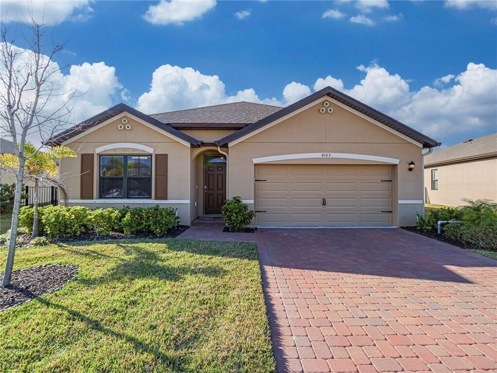 A single-story house with a tan stucco exterior, a two-car garage, and a brick driveway — 4103 Keeson Circle, Vero Beach FL 32967, VERO BEACH, FL
