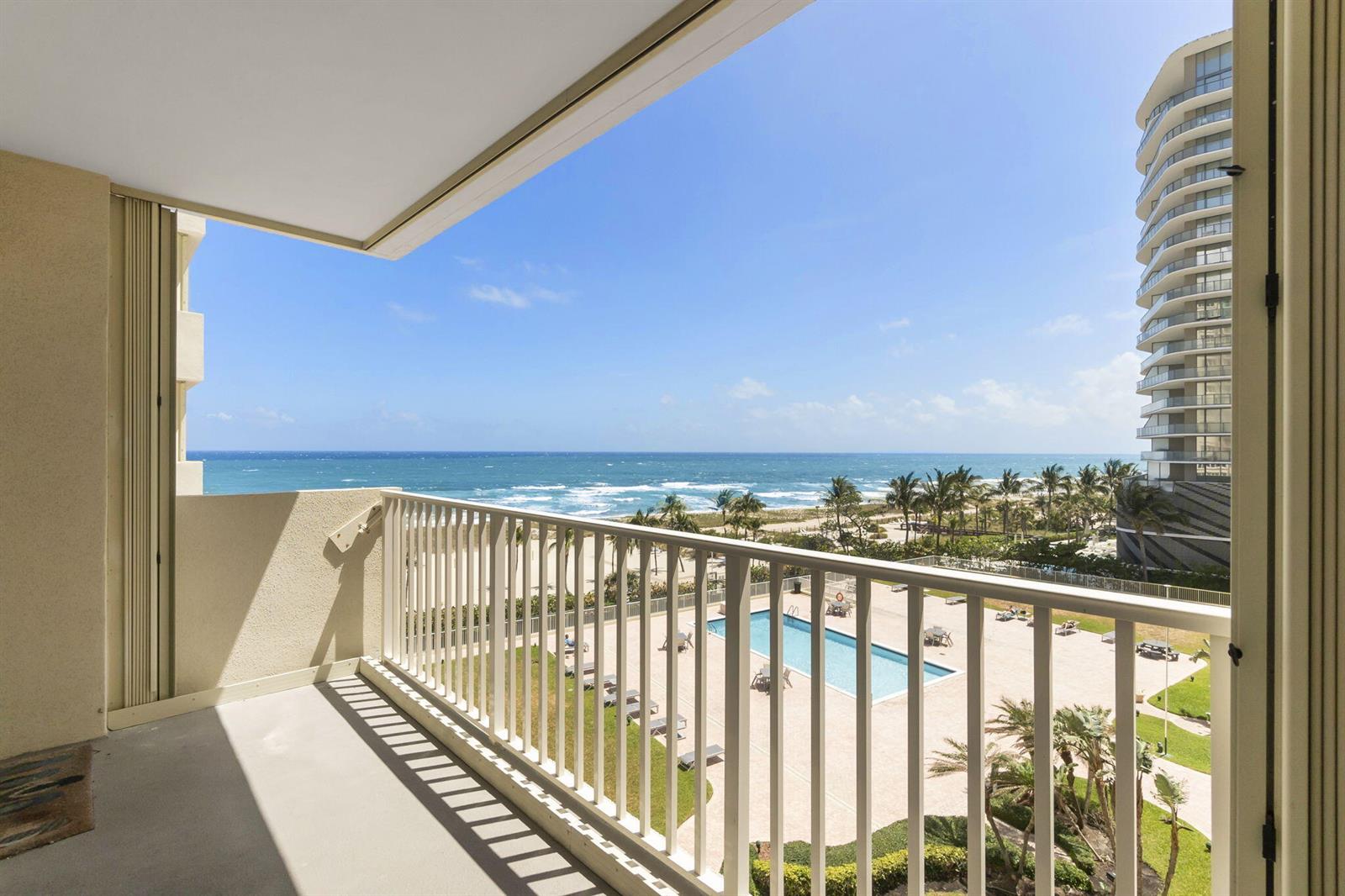 A balcony with a white railing overlooks a swimming pool, beach, and ocean — 750 N Ocean Boulevard Apt 604, Pompano Beach FL 33062, POMPANO BEACH, FL