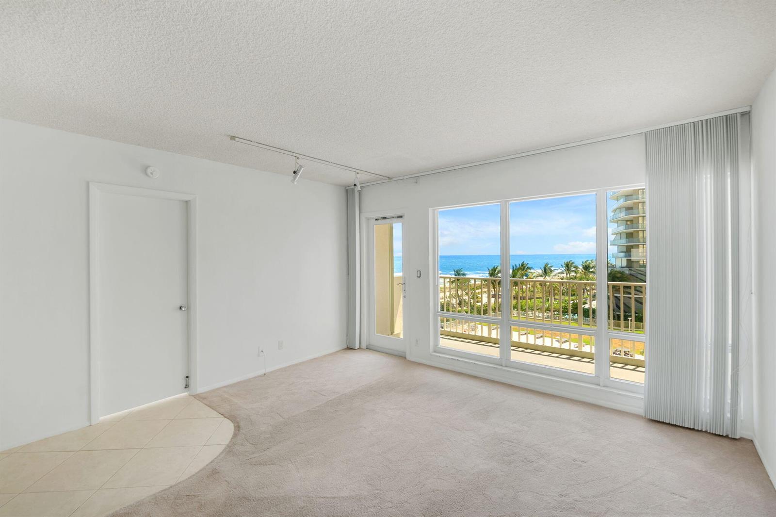 An empty room with beige carpet, white walls, and a balcony overlooking the ocean — 750 N Ocean Boulevard Apt 604, Pompano Beach FL 33062, POMPANO BEACH, FL