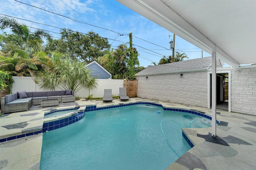 A backyard swimming pool with a spa, patio furniture, and a white stone wall — 2219 16TH STREET N, ST PETERSBURG, FL