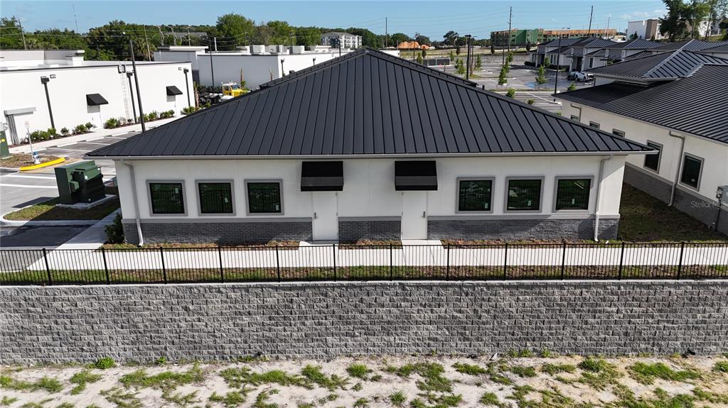 An exterior view of a single-story commercial building with a black metal roof — 2835 OCOEE APOPKA ROAD UNIT 13, APOPKA, FL