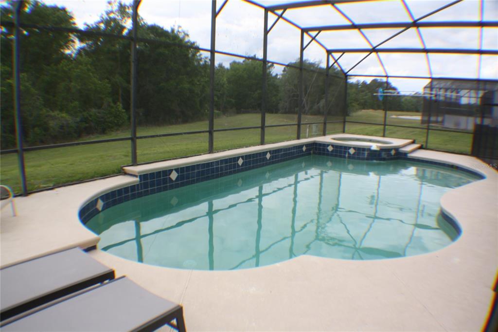 A kitchen features wood cabinets, stainless steel appliances, and a tiled breakfast bar — 8515 PALM HARBOR DRIVE, KISSIMMEE, FL