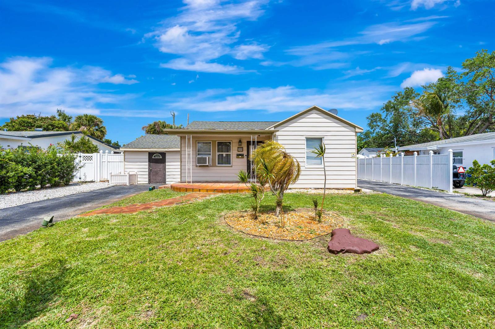 A single-story house with light siding, a front porch, and a grassy yard — 505 Foresteria Drive, Lake Park FL 33403, LAKE PARK, FL