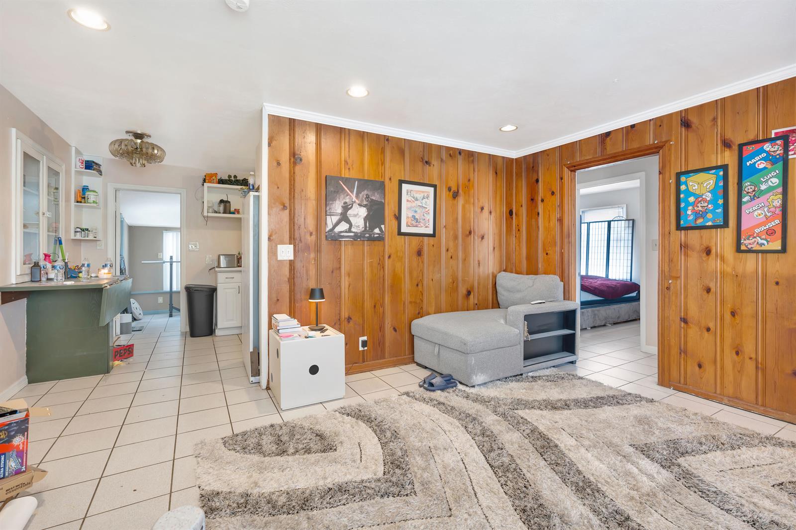 A living room features a brick fireplace, wood-paneled walls, tile flooring, and a desk area — 505 Foresteria Drive, Lake Park FL 33403, LAKE PARK, FL