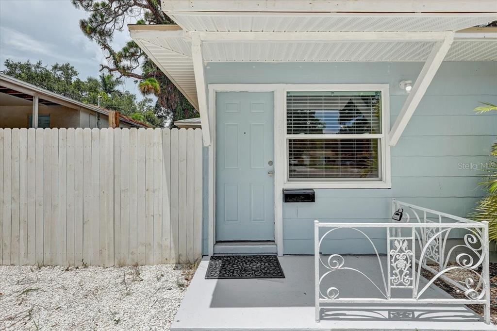 A light blue house exterior features a front door, a window, and a white railing — 2901 DR MARTIN LUTHER KING JR STREET S, ST PETERSBURG, FL