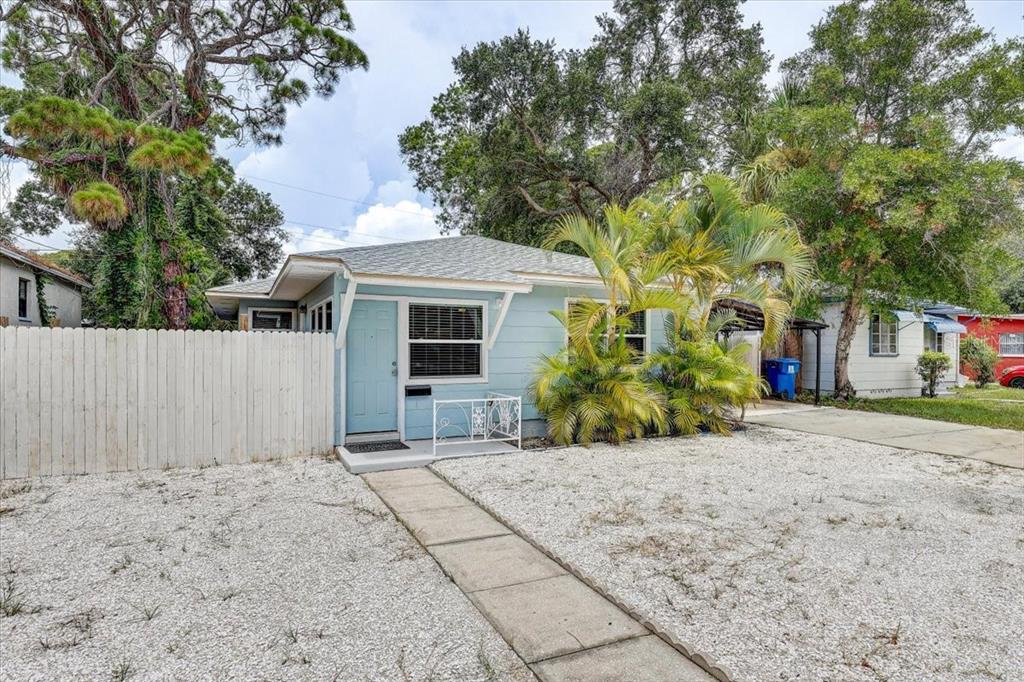 A light blue single-story house with a white fence, gravel yard, and a concrete walkway — 2901 DR MARTIN LUTHER KING JR STREET S, ST PETERSBURG, FL