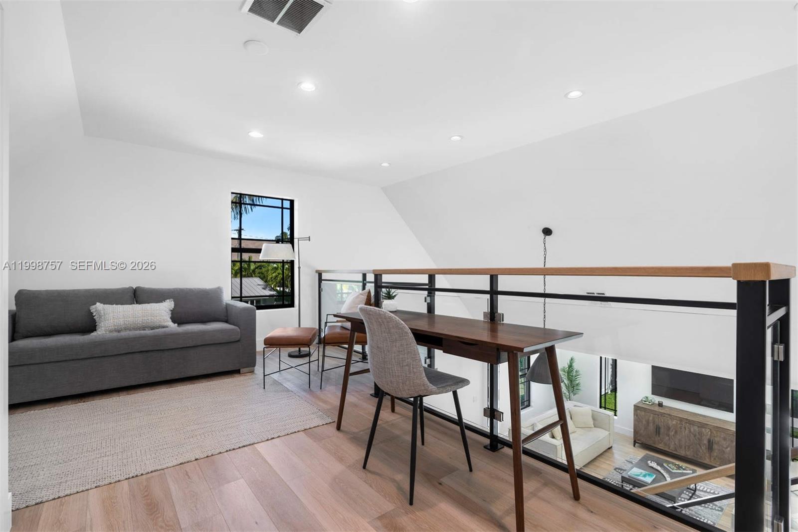 A loft area features a gray sofa, a wooden desk, and a glass railing overlooking downstairs — 18 Hersey Dr, Ocean Ridge FL 33435, OCEAN RIDGE, FL