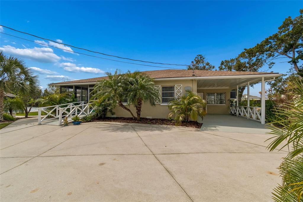 A single-story house with a concrete driveway, a carport, and a ramped entrance — 14539 COFFEY LANE, HUDSON, FL