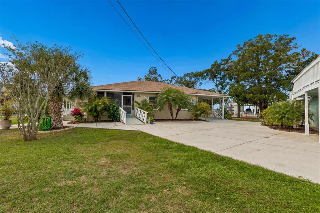 A single-story house with a concrete driveway, a ramp to the entrance, and palm trees — 14539 COFFEY LANE, HUDSON, FL