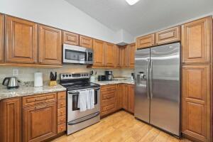 A kitchen with wood cabinets, stainless steel appliances, and granite countertops — 3130 Millwood Terrace # 2110, Boca Raton FL 33431, BOCA RATON, FL