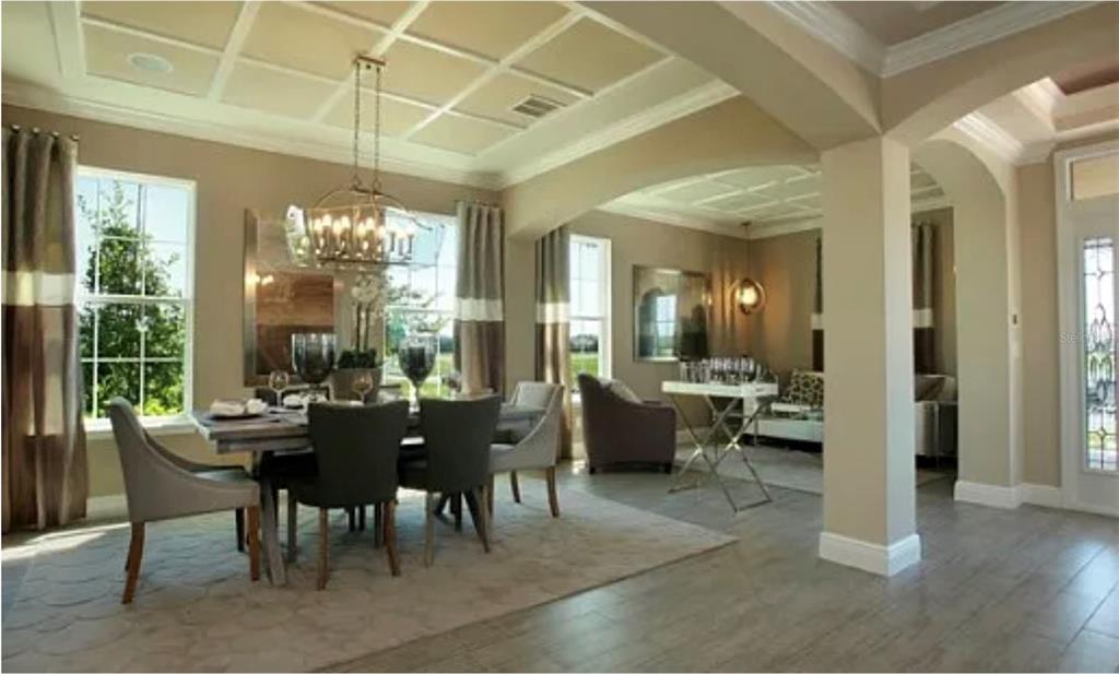 A dining room with a coffered ceiling and chandelier opens into a living area — 11835 GOLD CREEK TRAIL, WINDERMERE, FL