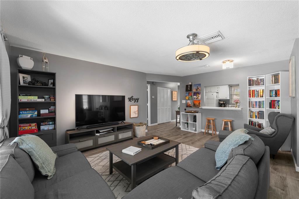 A living room features gray walls, a sectional sofa, a television console, and built-in shelving — 1960 UNION STREET UNIT 28, CLEARWATER, FL