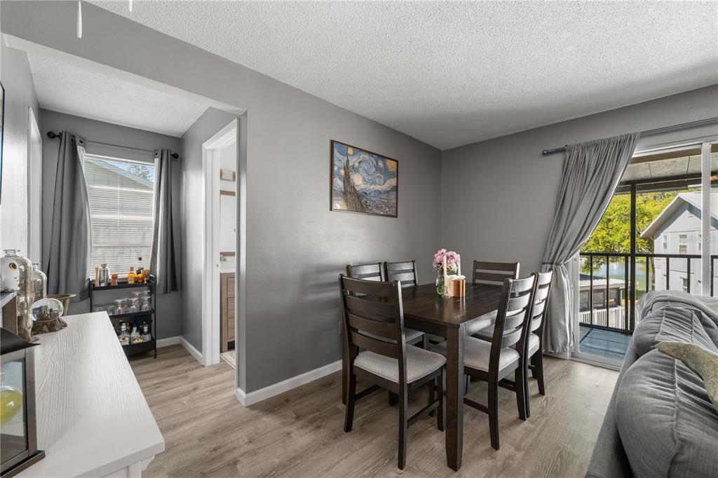 A dining area with a dark wood table, gray walls, and a sliding glass door — 1960 UNION STREET UNIT 28, CLEARWATER, FL