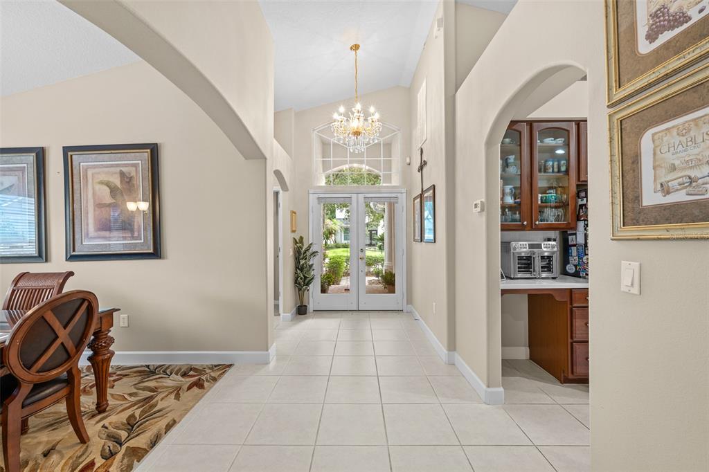 A tiled entryway features a chandelier, arched doorways, and a view of the front door — 16230 NOTTINGHAM PARKWAY, TAMPA, FL