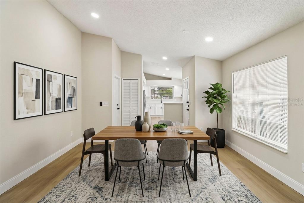 A dining room features a wooden table, six chairs, a patterned rug, and wall art — 106 LAMPLIGHTER DRIVE, SANFORD, FL