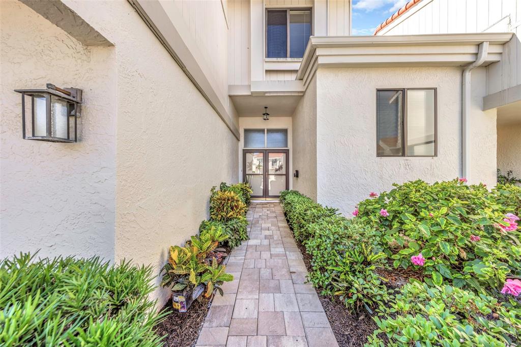 A stone walkway leads to the double front doors of a white stucco house — 5650 ESCONDIDA BOULEVARD S, ST PETERSBURG, FL