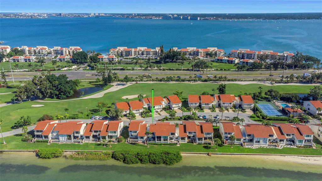 An aerial view of a waterfront townhouse complex with red tile roofs and a golf course — 5650 ESCONDIDA BOULEVARD S, ST PETERSBURG, FL