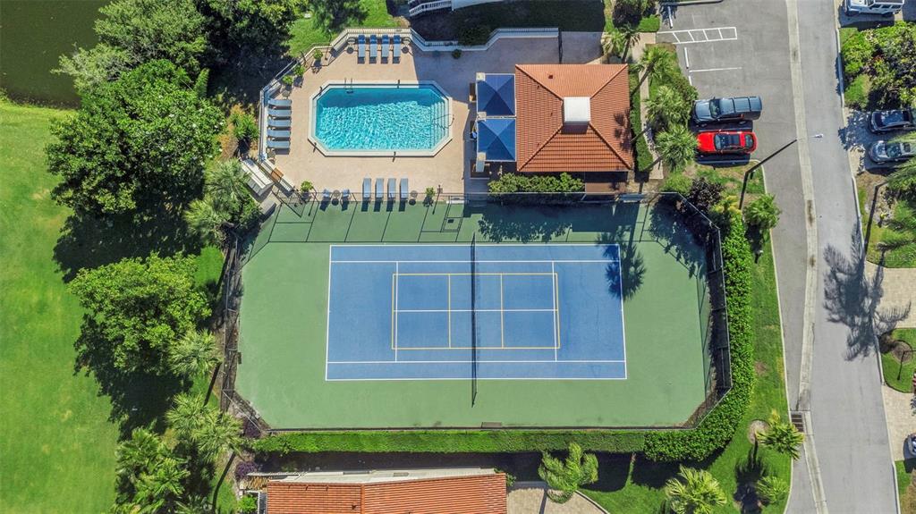 An aerial view shows a tennis court, a swimming pool, and a clubhouse with parking — 5650 ESCONDIDA BOULEVARD S, ST PETERSBURG, FL