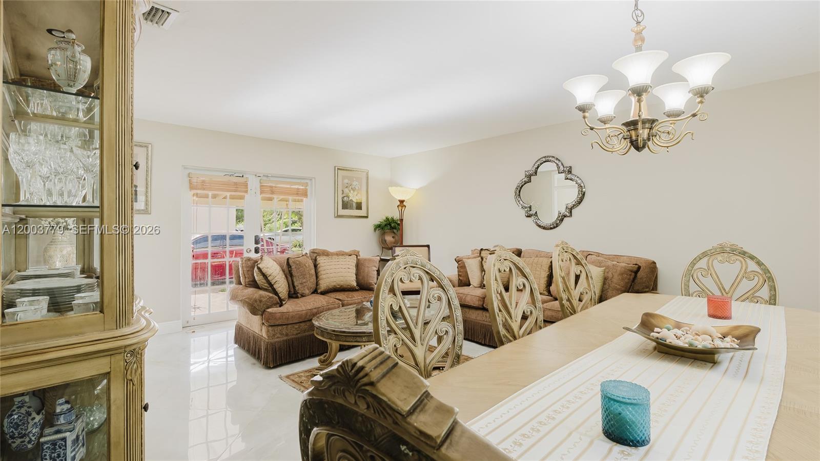 A dining area with an ornate table and chairs opens into a living room — 1300 NE 204th St, Miami FL 33179, MIAMI, FL